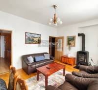 A bedroom in a three-room apartment with a wood-patterned floor and a double bed.