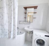 A hallway in a 3-room apartment with a wood-patterned floor and furniture.
