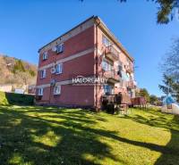 An apartment building with a 3-room apartment in Štiavnické Bane surrounded by a green lawn.