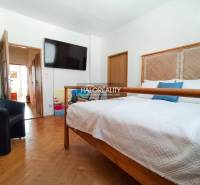 A bathroom in a 3-room apartment with a washing machine and a bathtub behind a curtain.