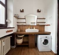 A bathroom in a 2-room apartment with wooden decor and a washing machine.
