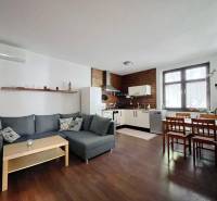 Living room with kitchen in a two-room apartment with a wooden decor floor.
