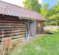 A wooden cottage in Horná Mariková, with a tin roof and surrounded by greenery.