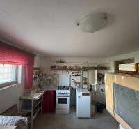 A kitchen in a family house with an older stove and bright red curtains.