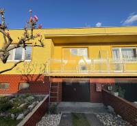 A family house in the city of Nové Zámky on Nové Zámky Street with a yellow facade and a garden.