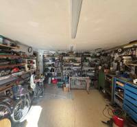 Workshop in a family house with tools, bicycles, and shelves full of materials.