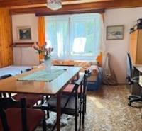 Living room in a family house with a dining table and flowers on it.