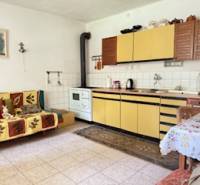 A kitchen in a family house with beige kitchen cabinets and a tiled stove.