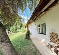 A family house in Krivosúd-Bodovka with a traditional facade, a bench, and a tree in the garden.