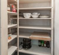 Pantry with shelves and kitchenware in a 3-room apartment.