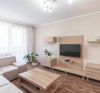 Living room of a three-room apartment with a wooden decor floor and a comfortable sofa.