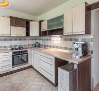 A kitchen in a 3-room apartment with a functional unit and tiled wall cladding.