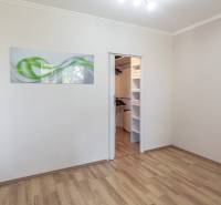 A room with a wooden floor decor and a built-in wardrobe in a 3-room apartment.