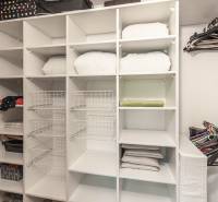 Storage space with shelves and hangers in a 3-room apartment with a wooden decor floor.