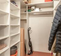 A wardrobe in a 3-room apartment with shelves and space for hanging clothes.
