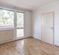 A room in a 3-room apartment with a wooden decor floor and large windows.