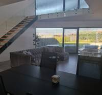 Dining table and staircase in a family house with a view of the garden.