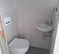A small bathroom in a family house with a washing machine and a sink.