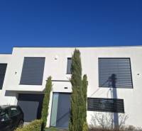 A family house in Zvončín with a minimalist facade and a landscaped front garden.