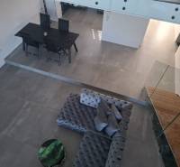 Interior of a family house with a view of the dining table, sofa, and staircase.