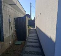 A narrow side path with gravel in a Family House in Zvončín.