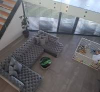 Living room in a family house with a large sofa, children's corner, and stairs.