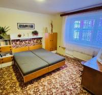 A room in a 3-room apartment with wooden decor furniture and a carpet on the floor.