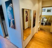 A hallway with a mirror and a wooden decor floor in a 3-room apartment.