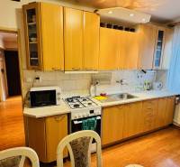 A kitchen in a 3-room apartment with a wooden decor countertop and flooring.