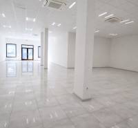 Spacious commercial spaces with white walls and shiny floors.