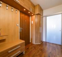 Entrance hallway in a 3-room apartment with wood-patterned flooring and built-in furniture.
