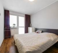 Bedroom in a 3-room apartment with a wooden decor floor and a bed.