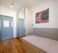 Children's room in a 3-room apartment with a wooden decor floor and abstract art on the wall.
