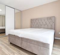 Bedroom in a 3-room apartment with a comfortable bed, built-in wardrobe, and floor with a wooden decor.