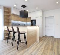 A kitchen in a 3-room apartment with a bar counter and a wooden decor floor.