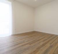 A room in a 3-room apartment with a wooden decor floor and a simple design.