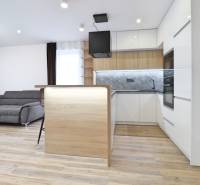 Living room with kitchen and wooden decor flooring in a 3-room apartment.