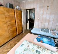 Bedroom in a 3-room apartment with a large wooden wardrobe and a floor with a wooden decor.