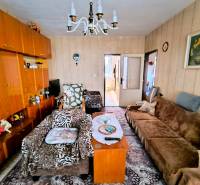 Living room in a 3-room apartment with wooden decor, carpet, and sofas.