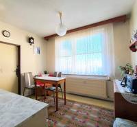 A dining room with simple furniture in a 3-room apartment, a floor with a decorative carpet.