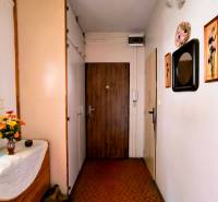 The hallway of a 3-room apartment with decorative pictures and floral decorations.