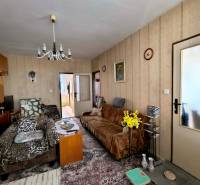 Living room in a 3-room apartment with armchairs, flowers, and a vintage chandelier.