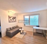 Bright living room in a 3-room apartment with wood-patterned flooring and a dining table.