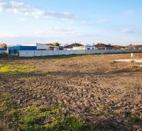Commercial land in Kráľová nad Váhom with a spacious open area and fenced buildings.