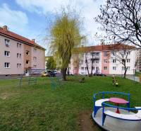 Playground with climbing frames and trees on Mierova Street in Sabinov, in front of a 2-room apartment.