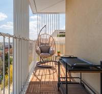 A balcony of a 3-room apartment in Bratislava-Ružinov with a swing and a view of the city.