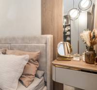 A bedroom in a 3-room apartment with a bed, a mirror, and decorative elements.