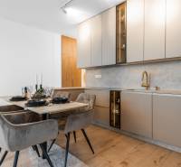 A kitchen in a 3-room apartment with a dining table and a floor with a wooden decor.