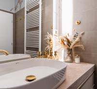 A bathroom with gold details and decoration in a 3-room apartment.