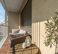 Balcony in a 3-room apartment with comfortable seating, view, and decorations.